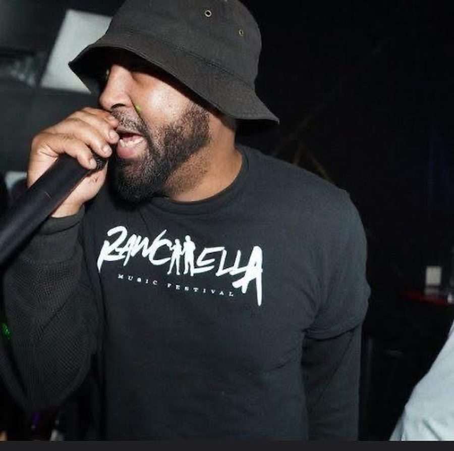 A performer on the mic in a Rawchella Music Festival shirt